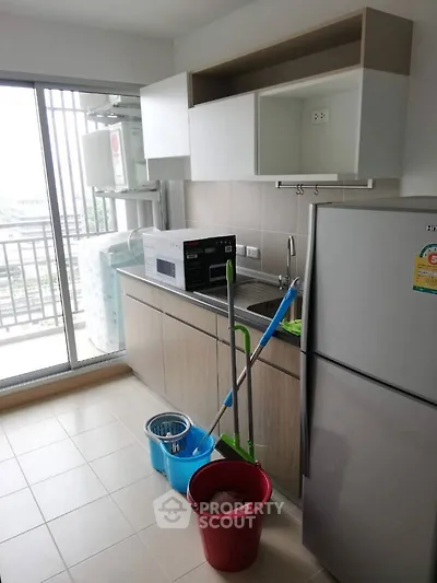 Modern kitchen with balcony view, featuring sleek cabinetry and appliances.