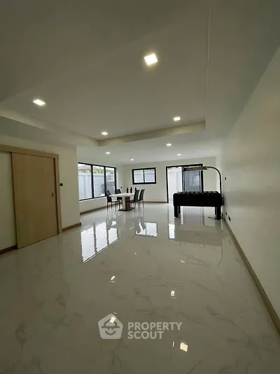 Spacious modern living room with glossy marble floors and large windows for natural light.