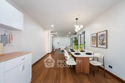 Spacious dining area with modern decor and wooden flooring in a stylish apartment.
