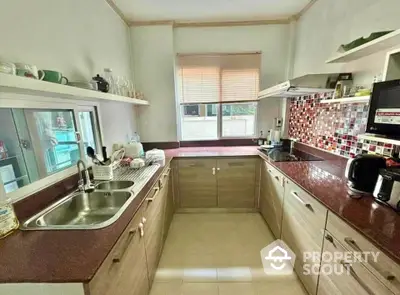 Modern kitchen with sleek countertops and stylish backsplash in a cozy home setting.