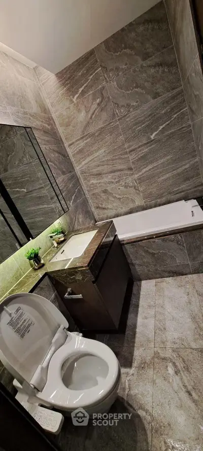 Luxurious modern bathroom with sleek design and elegant fixtures, featuring a bathtub and stylish tiling.