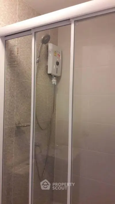 Modern bathroom with glass shower enclosure and electric water heater