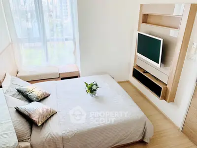 Modern bedroom with stylish decor and large window offering city views