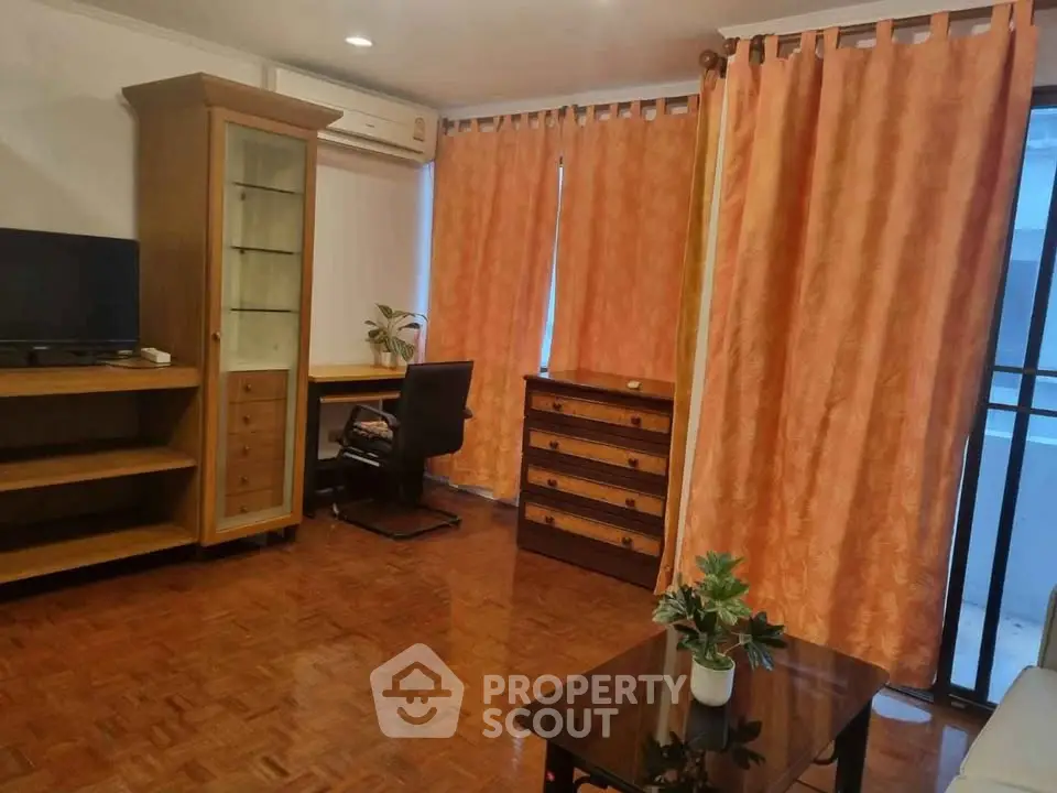 Spacious living room with wooden flooring and elegant furniture, perfect for relaxation and entertainment.