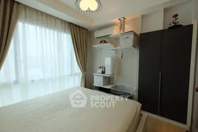 Cozy bedroom with large window and modern decor in a stylish apartment.