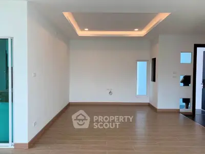 Spacious modern living room with recessed lighting and wooden flooring, ideal for customization.