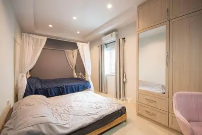 Spacious bedroom with two beds, large wardrobe, and modern decor