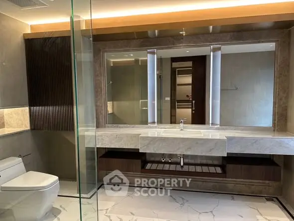 Luxurious modern bathroom with marble finishes and large mirror