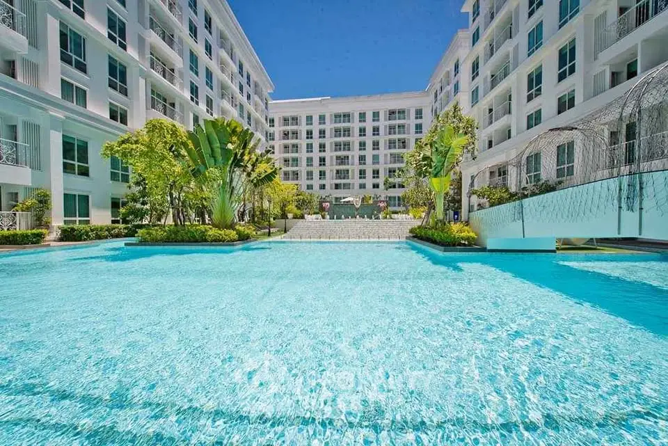 Luxurious apartment complex with stunning pool and lush greenery, perfect for modern living.