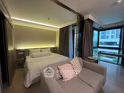 Modern bedroom with cozy sofa and large windows offering a stunning view in a luxurious apartment.