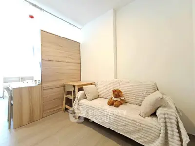 Cozy living room with a plush sofa and wooden accents, perfect for relaxation.