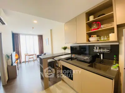 Modern open-layout kitchen and living area with stylish decor and natural lighting.