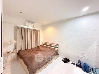 Cozy bedroom with modern decor and ample natural light, featuring a comfortable bed and stylish furnishings.