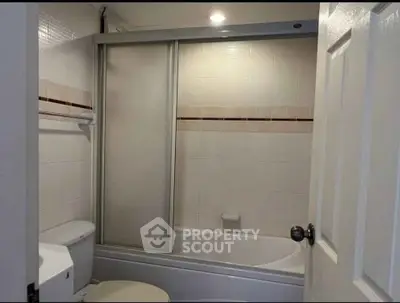 Modern bathroom with sliding glass shower door and tiled walls