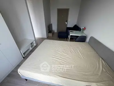 Modern studio apartment with cozy living area and spacious bed, ideal for urban living.