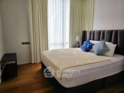 Cozy bedroom with elegant decor and natural light, featuring a plush bed and stylish furnishings.