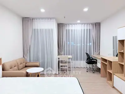 Modern studio apartment with cozy living area and study desk, featuring elegant curtains and neutral decor.