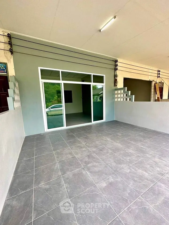 Spacious tiled entrance with sliding glass doors, perfect for modern living.