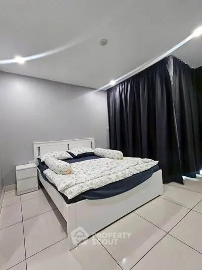 Modern bedroom with sleek design and cozy bedding in a stylish apartment.