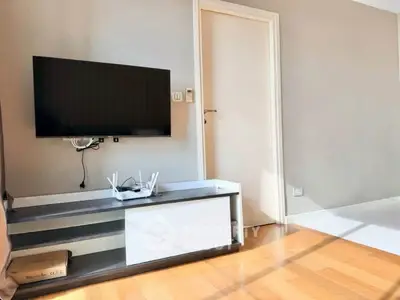 Modern living room with wall-mounted TV and sleek wooden flooring