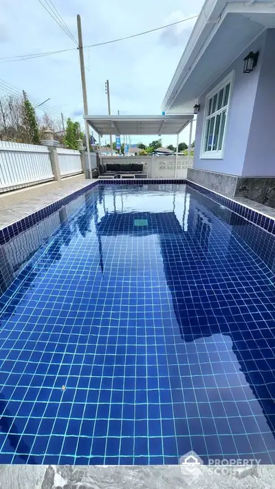 Stunning private pool with modern blue tiles in a serene residential setting.