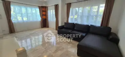 Spacious living room with large windows and elegant marble flooring