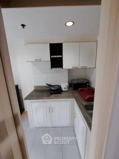 Cozy kitchen with modern appliances and granite countertops in a compact layout.