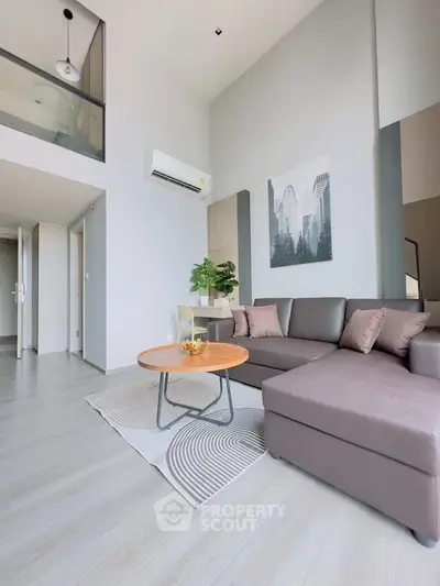 Modern living room with high ceilings, stylish decor, and comfortable seating in a contemporary apartment.