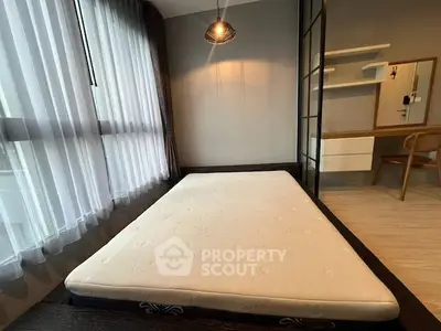 Modern bedroom with large window and minimalist decor, featuring a comfortable mattress and stylish lighting.