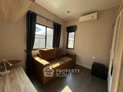 Cozy living room with sofa and air conditioning, perfect for relaxation.