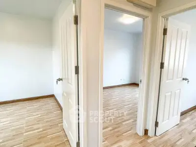 Spacious apartment with wooden flooring and white doors, perfect for modern living.