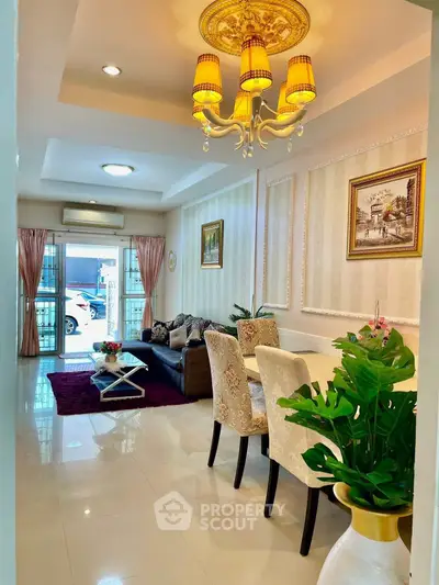 Elegant living room with chandelier, stylish decor, and natural light.