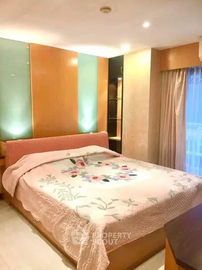 Cozy bedroom with elegant lighting and floral bedding in a modern apartment.