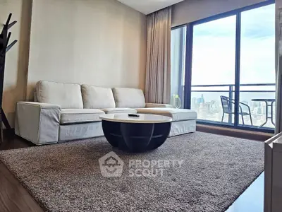 Spacious living room with modern sofa and city view balcony, perfect for urban living.