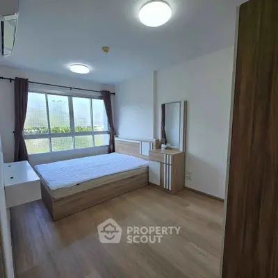 Modern bedroom with large window and stylish wooden furniture