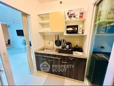 Modern compact kitchen with sleek cabinetry and appliances in a stylish apartment.