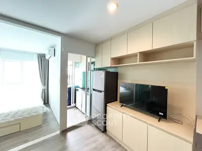 Modern apartment interior with open layout, featuring a cozy living area and sleek kitchen appliances.