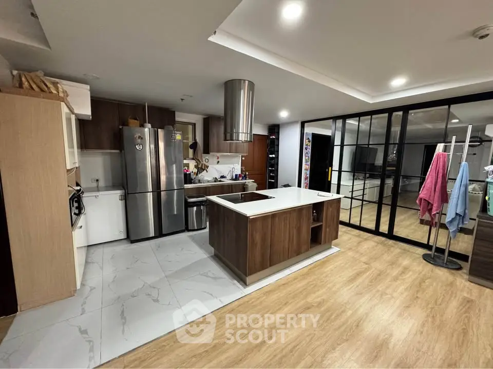 Modern kitchen with island and stainless steel appliances in open layout