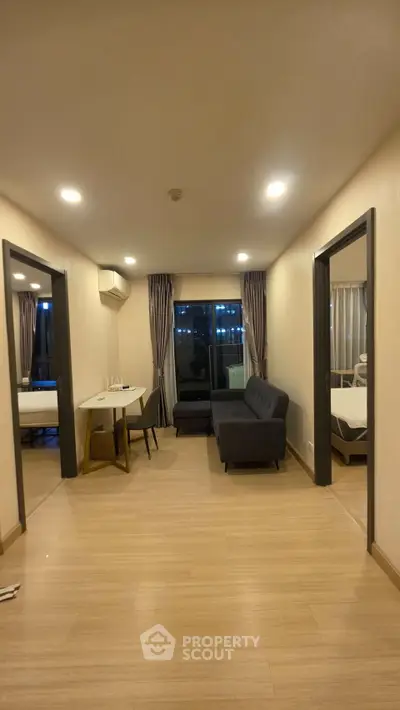 Modern apartment interior with cozy living room and dining area, featuring sleek furniture and ambient lighting.