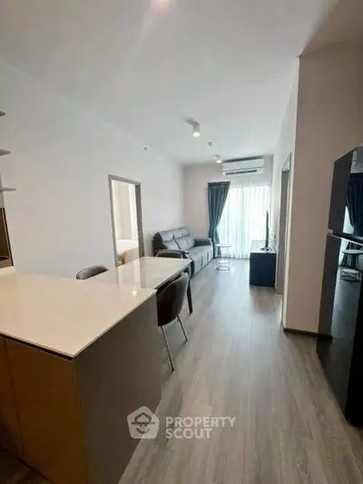 Modern living room with sleek design and natural light, featuring open layout and stylish furnishings.
