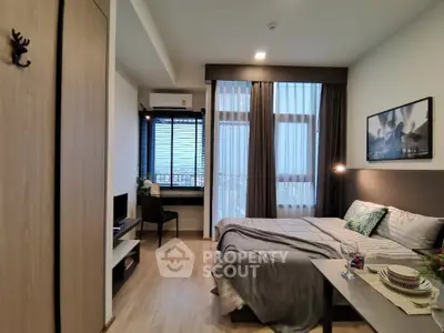 Modern bedroom with cozy decor and large windows for natural light