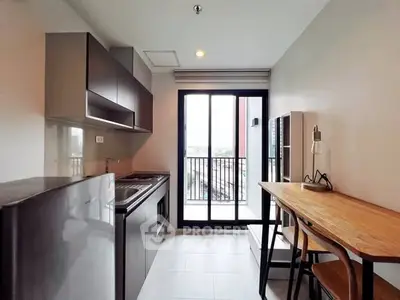Modern kitchen with sleek cabinets and balcony view, perfect for urban living.