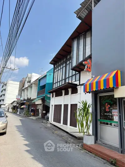 Charming urban street view with colorful awnings and modern architecture.