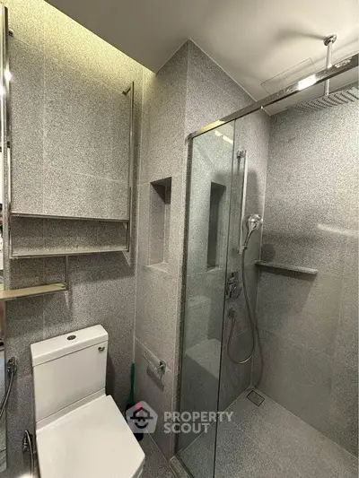 Modern bathroom with sleek shower and toilet in contemporary design.