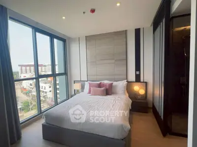 Modern bedroom with large windows and city view, featuring stylish decor and cozy ambiance.