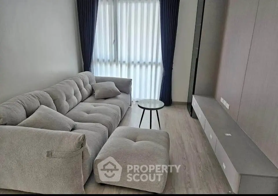 Modern living room with plush gray sofa and natural light