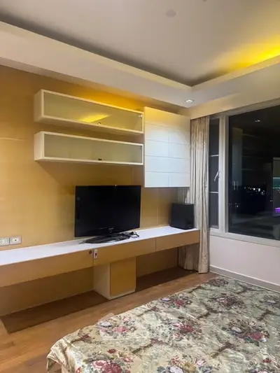 Modern bedroom with TV and large window offering city view