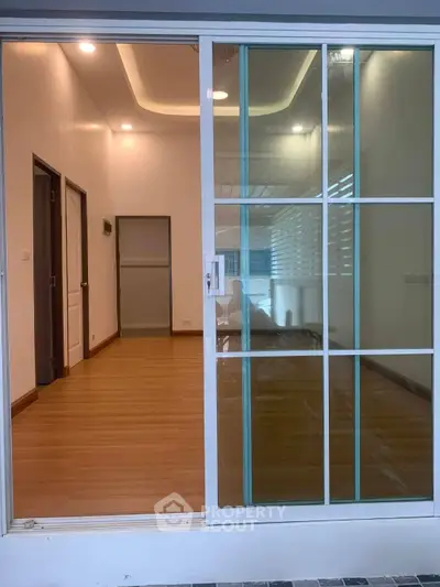 Spacious interior with sliding glass doors and wooden flooring, ideal for modern living.