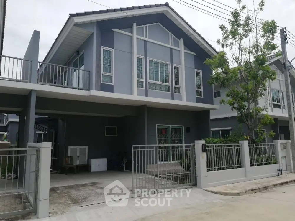 Modern two-story house with spacious driveway and gated entrance in suburban neighborhood.