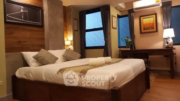 Cozy bedroom with elegant decor and ambient lighting, featuring a comfortable bed and stylish desk area.